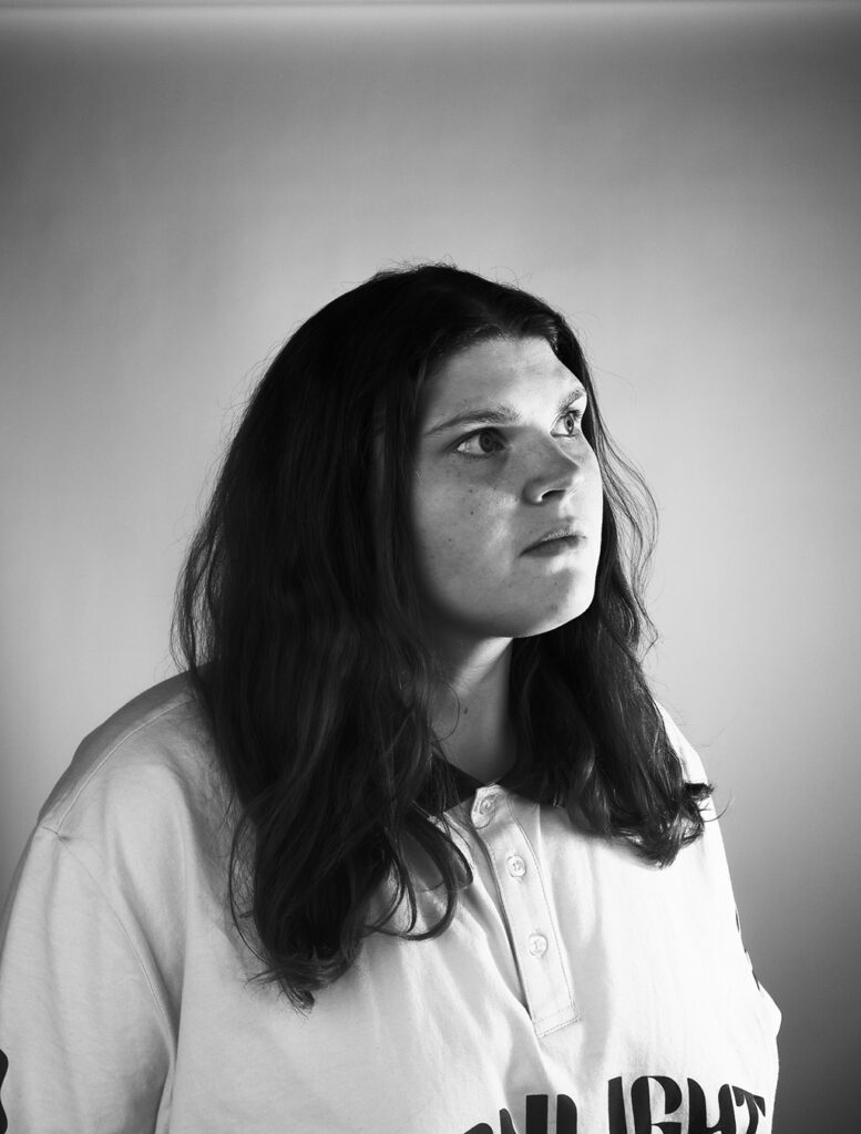 jezelf portret van saartje scheirs die schuin naar boven kijkt. saartje heeft los haar de foto is in zwart wit gemaakt